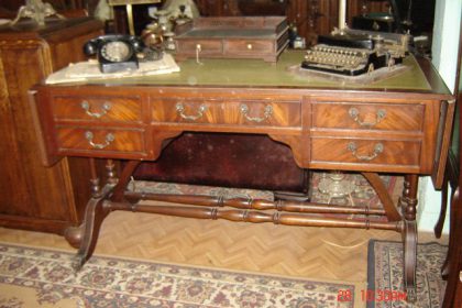 Εγγλέζικο Γραφείο παλιό σαλονιού από ξύλο μαόνι. Επένδυση πρασινου δέρματος με χρυσοτυπία και πλαινές προεκτάσεις. Οι δύο όψεις του είναι όμοιες λόγω του τρυκ των "ψεύτικων"συρταριών. circa 1880 M138(28+28)Π69Υ78. TIMH 950EURO